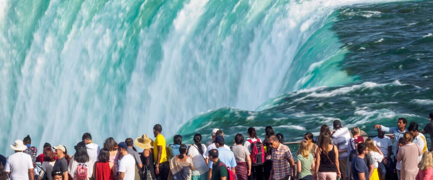 Un groupe de personnes se tient devant une grande cascade.