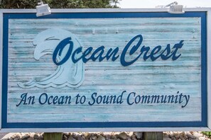 A sign with the text "Ocean Crest" and "An Ocean to Sound Community". - The Big Easy | 805 ft from the beach | Private Pool, Hot Tub, Dog Friendly | Duck (Duck)