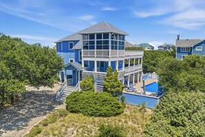 Una casa de varios pisos con balcón, piscina y vista al mar.