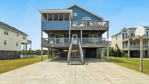 A multi-story building with a central staircase, balconies, and a flat roof.