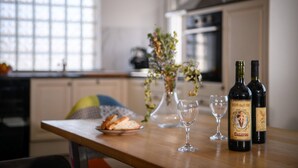 Un comptoir de cuisine avec une bouteille de vin, un verre et une assiette de pain.