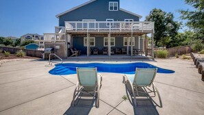Une maison à deux étages avec un balcon et une piscine.
