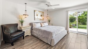 A bedroom with a bed, a chair, a ceiling fan, and a large window with a view of greenery. - Gilbert Home, Walk to Downtown, Restaurants, Nightlife 10+ location! (Gilbert)