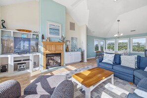 A spacious living room with a fireplace, a sofa, a coffee table, and a TV.