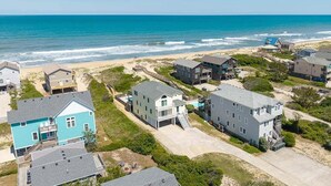 A coastal residential area with houses, a beach, and a clear view of the ocean. - Glistening Sands | Oceanfront | Private Pool, Hot Tub | Nags Head (Nags Head)