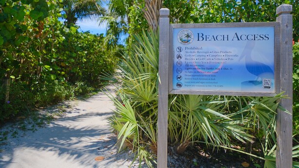 A beach access sign with prohibitions and guidelines for beachgoers.