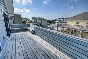 Eine Holzterrasse mit Blick auf umliegende Häuser und einem klaren Himmel.