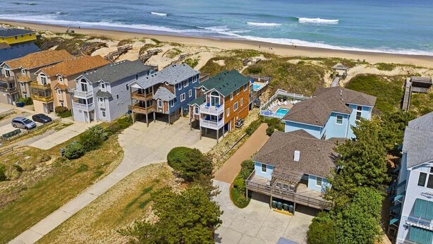 A coastal residential area with houses, a beach, and a clear view of the ocean. - Sweet Isabel | Oceanfront | Private Pool, Hot Tub | Nags Head (Nags Head)