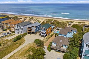 Un quartier résidentiel situé sur la côte, avec des maisons, une plage et une vue dégagée sur l’océan.