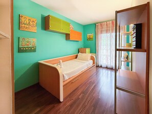 A room with a wooden bed, a green wall, and a window with curtains. - Megan Apartment by Hello Homes Sitges (Sitges)