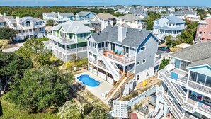 Uma área residencial costeira com casas que têm varandas e uma piscina.