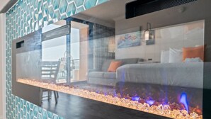 Un intérieur moderne avec une surface réfléchissante, un mur orné de motifs et une pièce visible contenant un lit et une fenêtre.