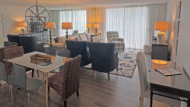 A modern living room with a dining area, featuring a chandelier, sofas, and lamps. - Spectacular OCEAN VIEWS - Fabulous Kingston South Hampton 3rd fl unit (Myrtle Beach)