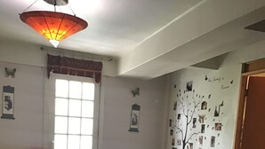 A living room with a sofa, chairs, a table, a decorative wall with photos, and a window with curtains. - Depa to share in Mexico City (Only Woman) (Roma Sur)