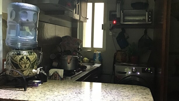 A kitchen with a granite countertop, a water dispenser, a microwave, and a toaster. - Depa to share in Mexico City (Only Woman) (Roma Sur)