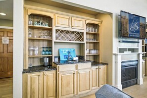 A kitchen with wooden cabinets, a granite countertop, and a blue sign on the counter.