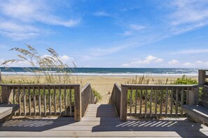 Un camí de fusta que condueix a una platja amb una vista clara de l'oceà.