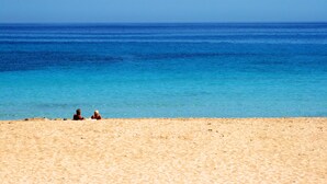 A beach with clear blue water and sandy shore. - Historic finca with modern comfort and panoramic views, pool, calm nature, WiFi (Son Serra de Marina)