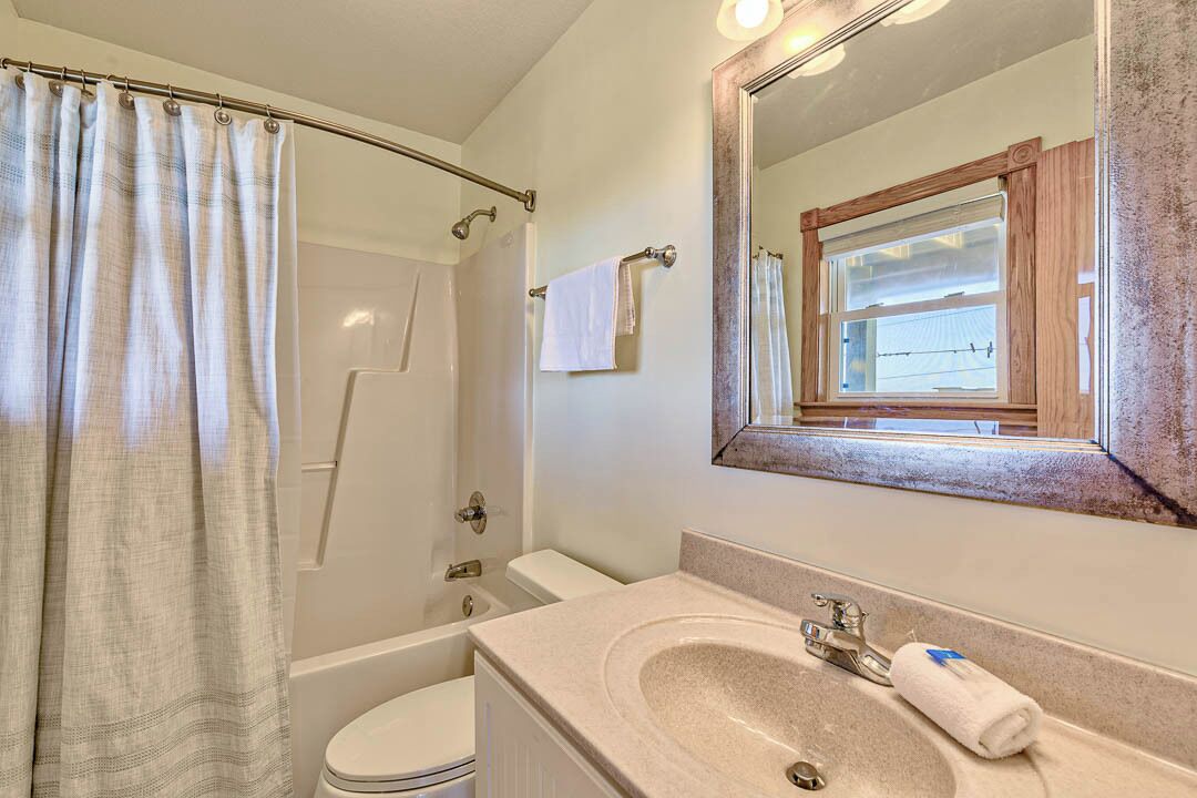 A bathroom with a bathtub, toilet, and sink.