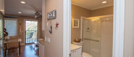 Un baño con ducha de vidrio, inodoro y lavabo.