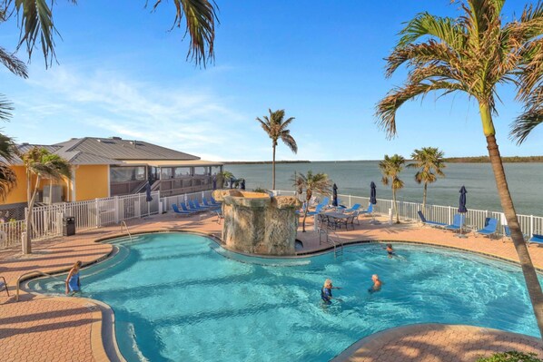 Relax by the pool surrounded by palm trees and ocean views, with lounge chairs and umbrellas at your disposal.