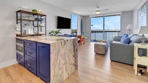 Una cucina moderna con isola in marmo, elettrodomestici integrati e zona pranzo con vista sul mare.