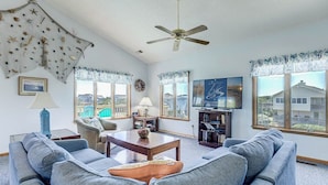 A living room with a ceiling fan, two sofas, a coffee table, a TV, and a bookshelf. - Even Steven | 570 ft from the beach | Private Pool | Duck (Duck)