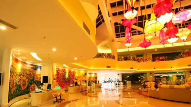 A spacious lobby with a reception desk, a mural of sunflowers, and a ceiling adorned with hanging lanterns. - Floloving Hotel (Guangzhou)