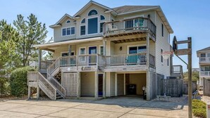 Ein zweistöckiges Haus mit Balkon, überdachter Veranda und Garage.