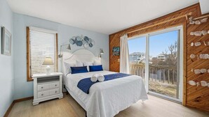 Ein Schlafzimmer mit Bett, Nachttisch und Blick ins Freie.