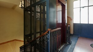 Eine Treppe mit Metallgeländer, einem Holzhandlauf und einer Tür mit rotem Rahmen.