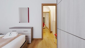 Ein Hotelzimmer mit Bett, Schreibtisch, Spiegel und Kleiderschrank.