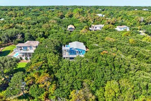 A residential area with multiple houses surrounded by dense greenery. - Breaking Winds | 850 ft from the beach | Private Pool, Hot Tub | Southern Shores (Southern Shores)
