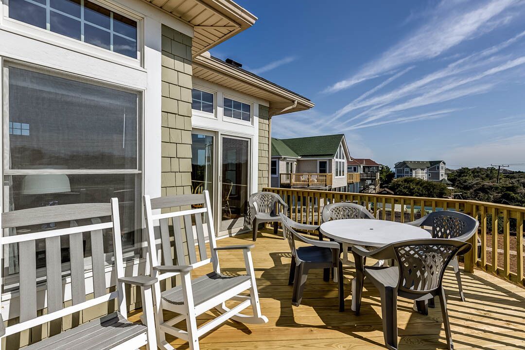 Una terraza con mesa y sillas, con vista a un área residencial.