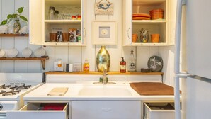A kitchen with white cabinets, a central island, and overhead lighting. - OCEAN BEACH, #7 ZEN, RETRO COTTAGE STUDIO, ONLY 3 BLOCKS TO THE BEACH 🏖 (San Diego)