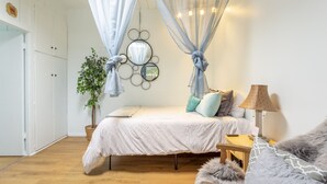 A bedroom with a bed, bedside table, lamp, and a potted plant. - OCEAN BEACH, #7 ZEN, RETRO COTTAGE STUDIO, ONLY 3 BLOCKS TO THE BEACH 🏖 (San Diego)