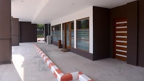 A modern building with a covered walkway, large windows, and a door with horizontal slats. - Green Paradise Hotel (Yangon)