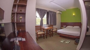 A hotel room with a bed, desk, chairs, and a window with curtains. - Green Paradise Hotel (Yangon)