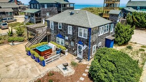 Una propiedad frente a la playa con una casa grande que cuenta con una terraza, una piscina y una torre de salvavidas.