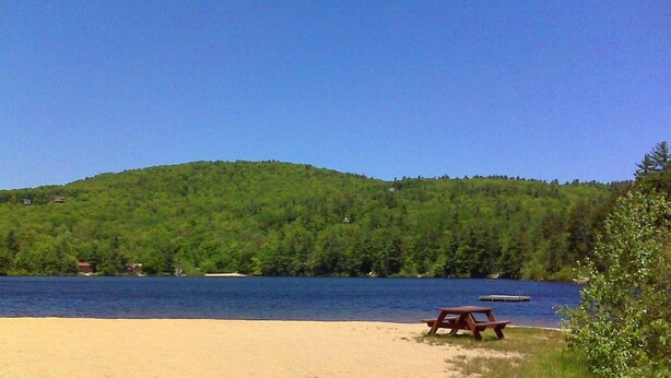 A beach with a picnic table and a lake in the background. - Beautiful Waterfront Home w/ Canoe & 1 Person Kayak. Close to North Conway (Madison)
