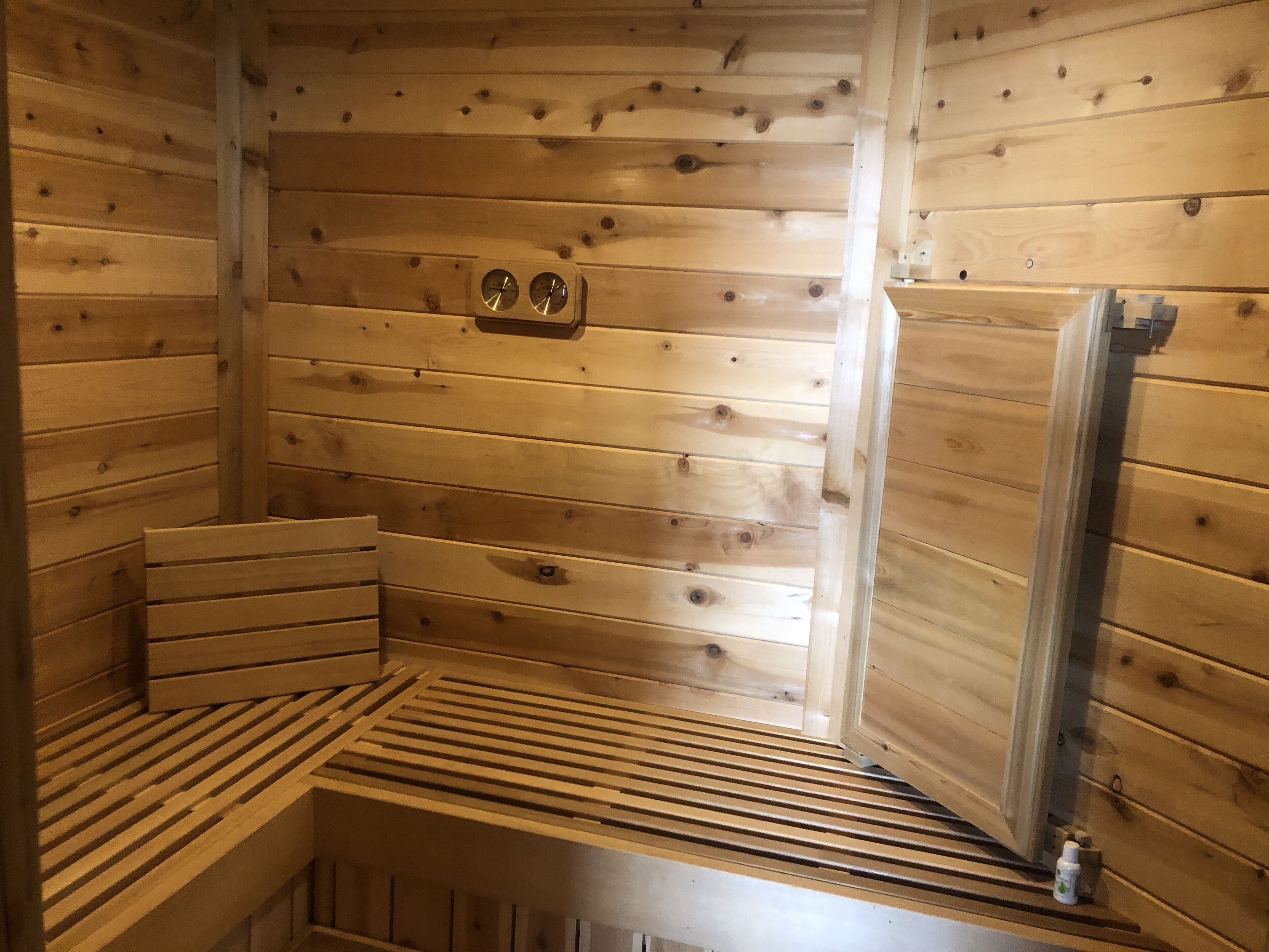 A wooden sauna with benches and a bench with a backrest.