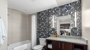 A modern bathroom with a shower, toilet, and vanity. - Studio King Suite with Kitchen | 304 (Asheville)