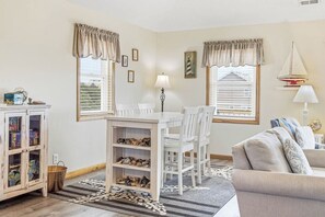 Una habitación con una mesa de comedor, sillas, un sofá y un armario con zapatos.