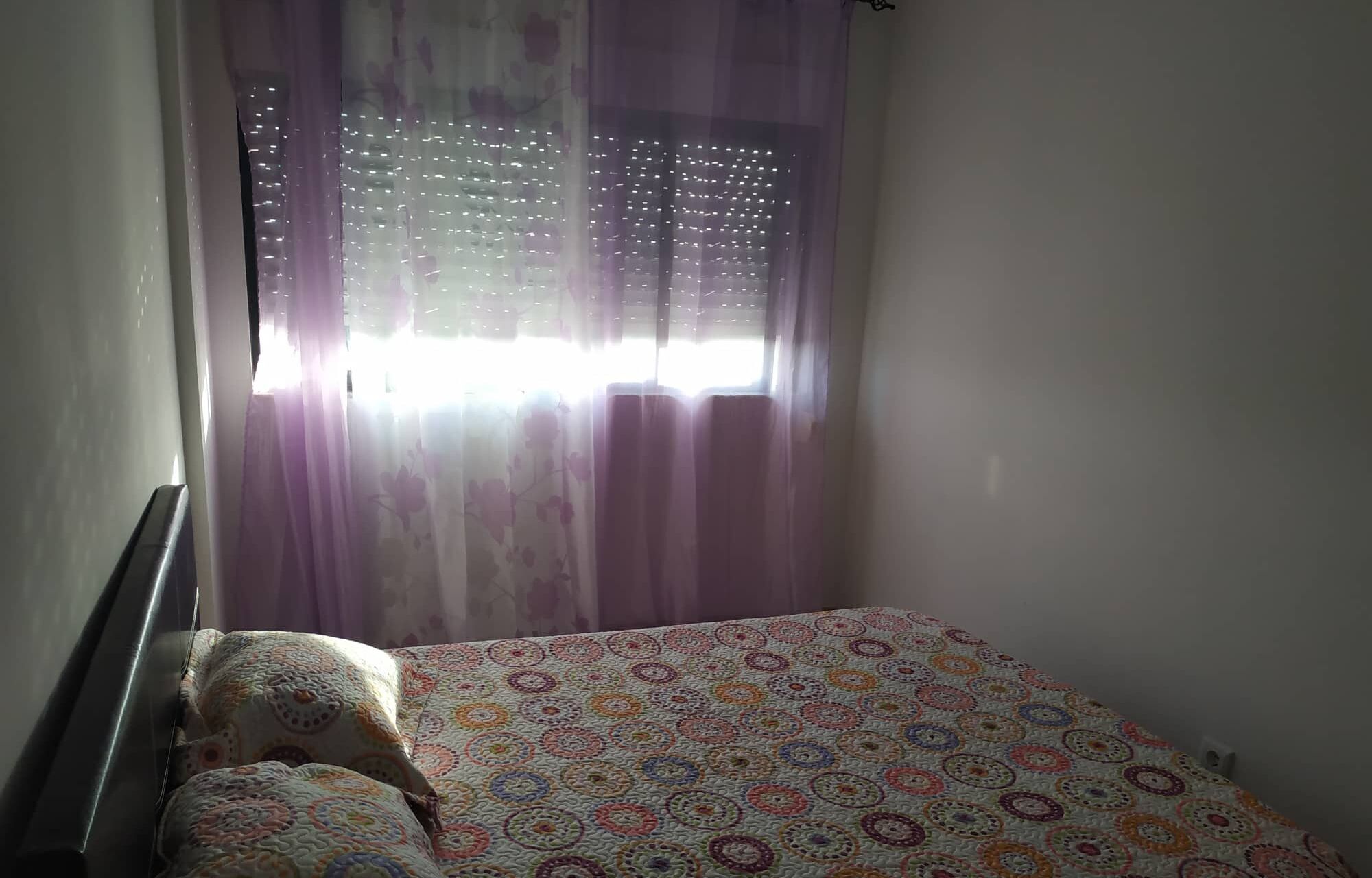 2 dormitorios y tabla de planchar con plancha