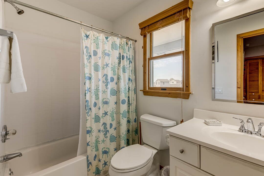 A bathroom with a bathtub, toilet, and sink.