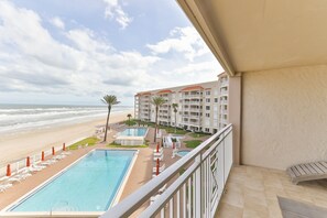 Un balcon d’hôtel avec vue sur la plage et l’océan.