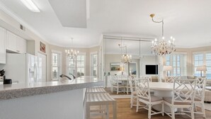 A spacious kitchen with a central island, white cabinetry, and a chandelier. - 81 Ocean Place - Lovely Oceanfront 3rd Floor With Views Of The Atlantic Ocean (Fernandina Beach)