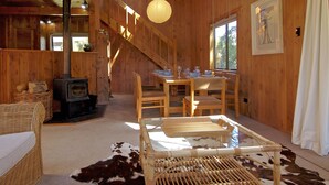 Un intérieur en bois avec une cheminée, un coin repas et un escalier.