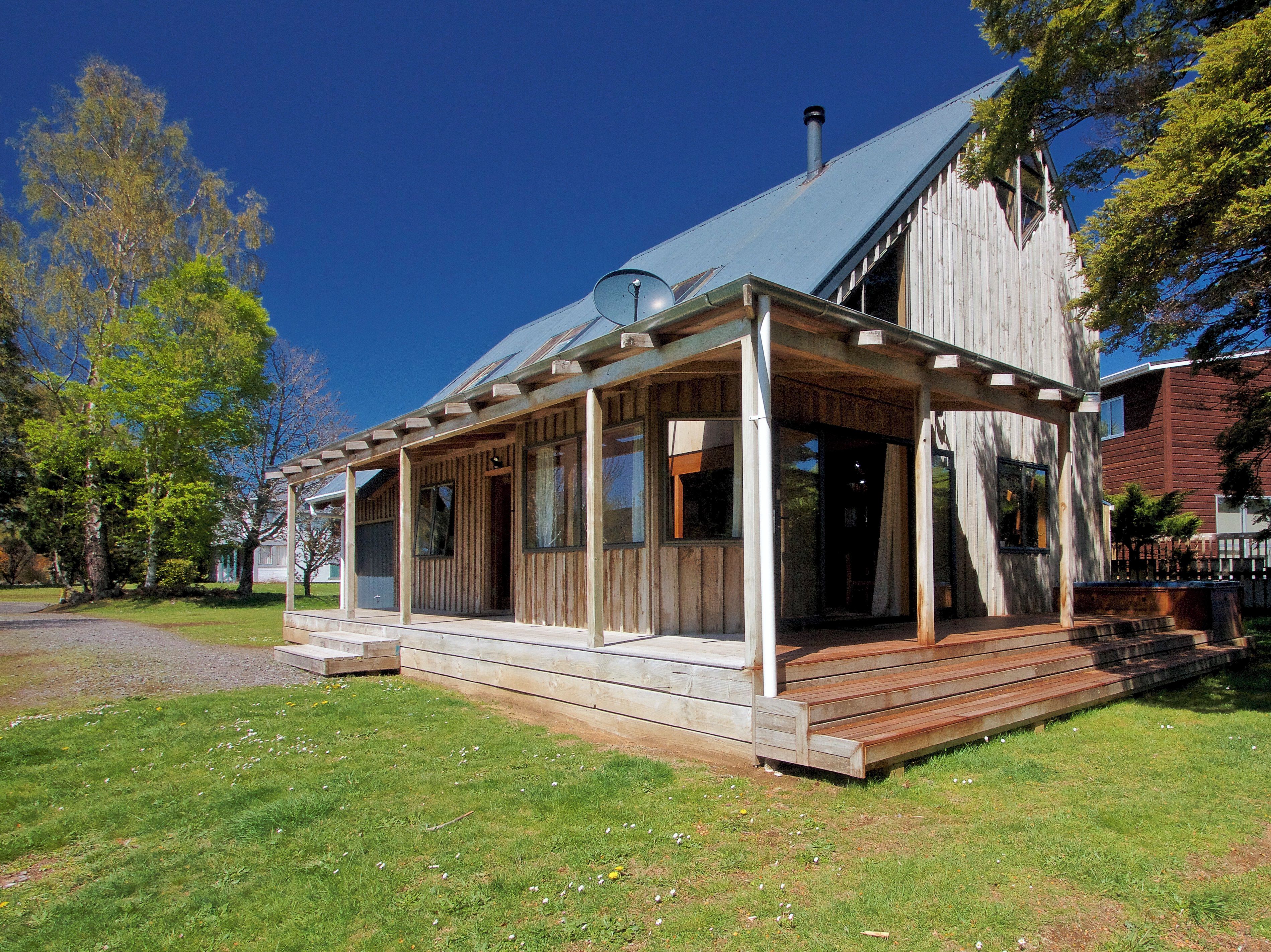 A wooden house with a covered porch and a chimney.