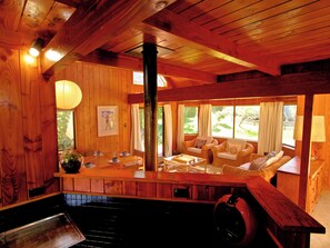 L’intérieur d’un chalet en bois comprend un coin repas, une cheminée et un espace salon confortable avec vue sur l’extérieur.